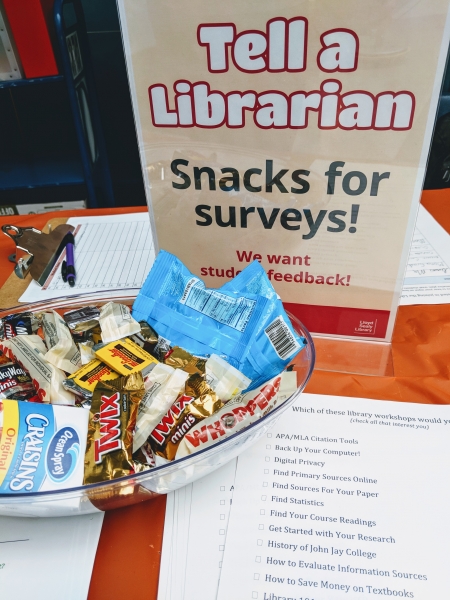 Snacks for Surveys sign, with candy and papers
